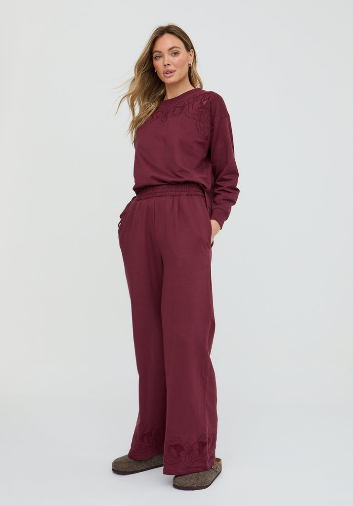 Woman wearing a burgundy outfit on a white background