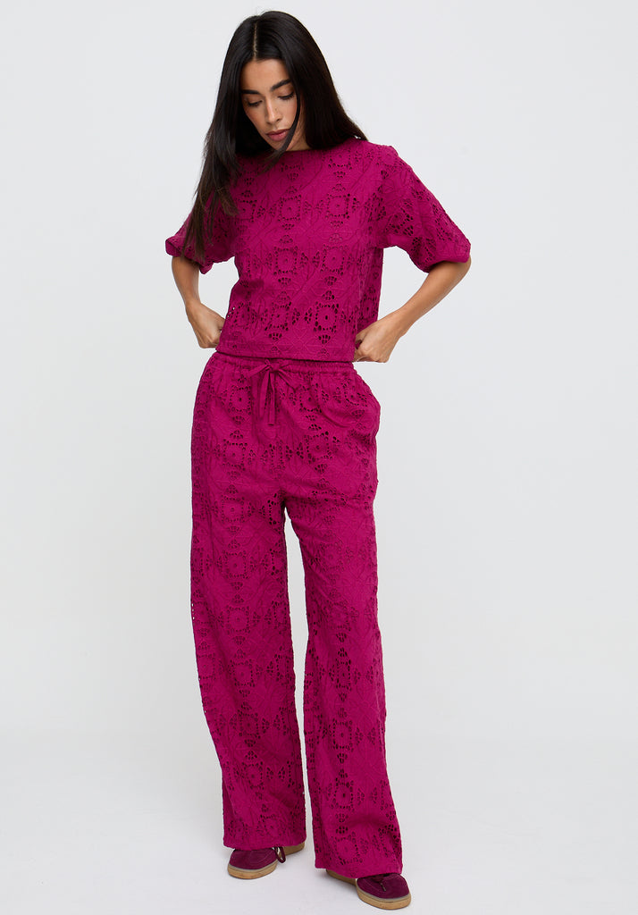 Woman wearing a pink patterned outfit on a white background