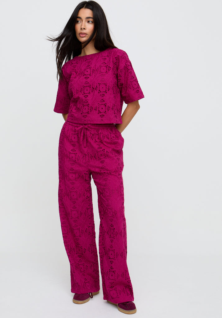 Woman wearing a pink patterned outfit on a white background