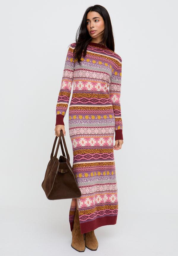 Woman wearing a patterned dress holding a brown bag on a white background