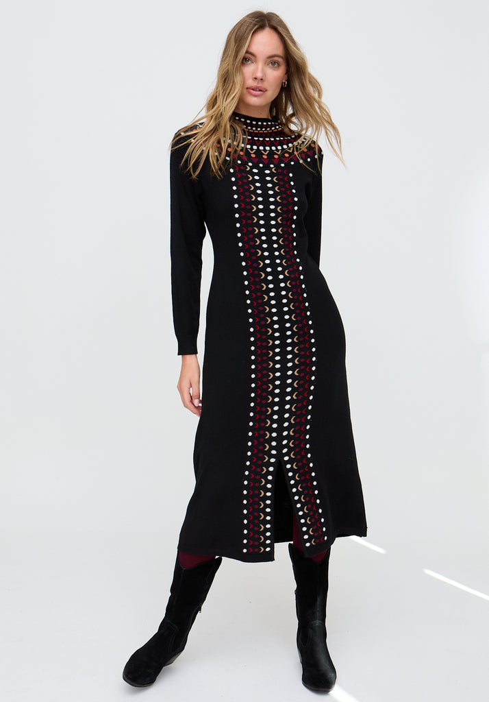 Woman wearing a black dress with a patterned design on a white background