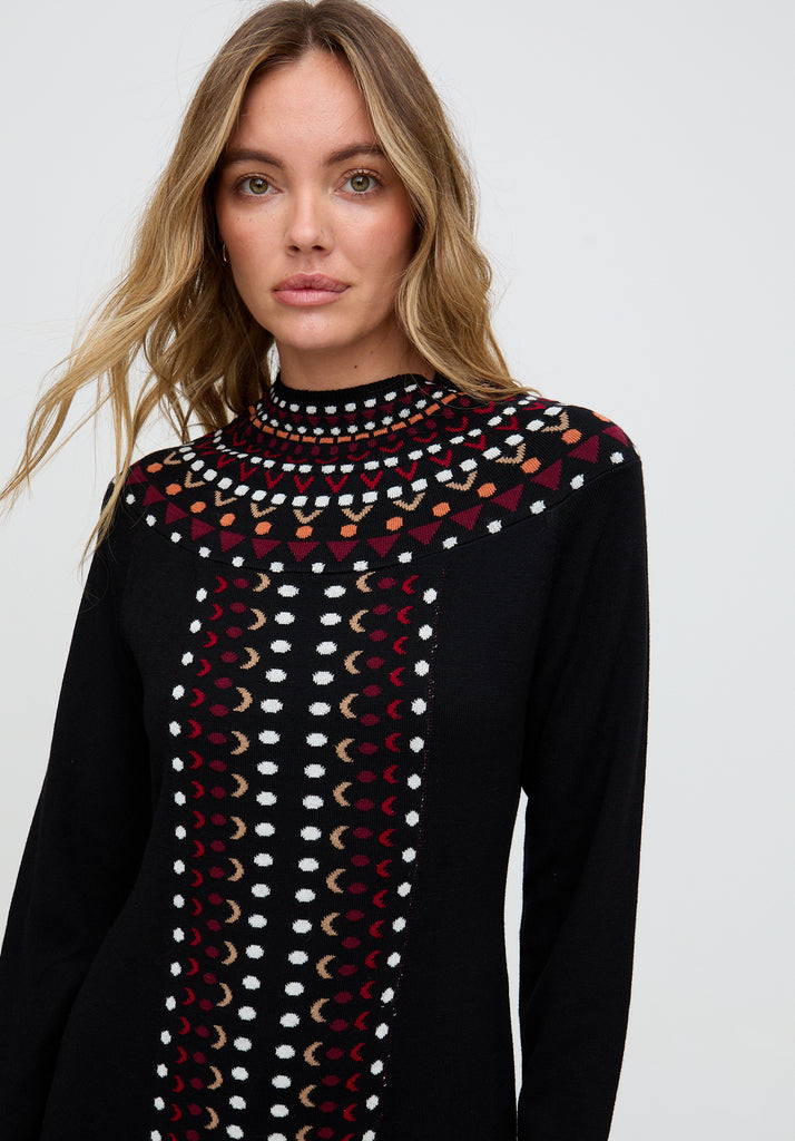 Woman wearing a black sweater with colorful pattern on a white background