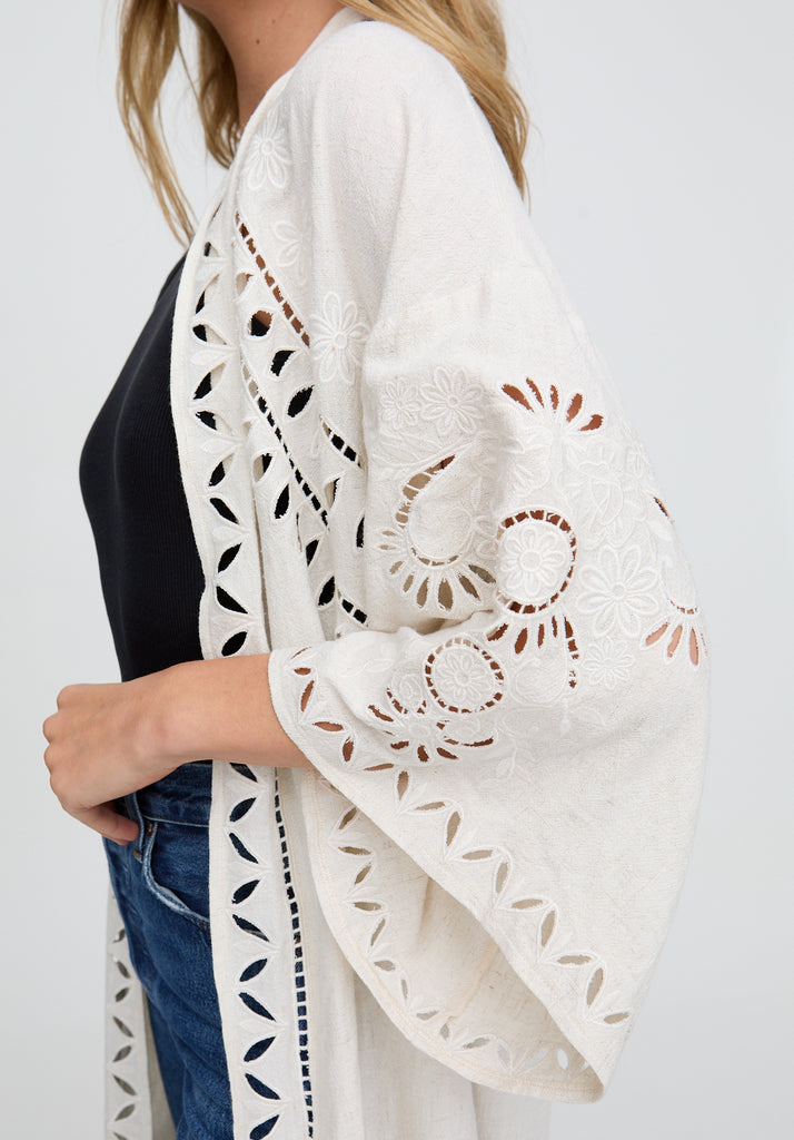 White lace kimono-style garment with cut-out patterns on a plain background