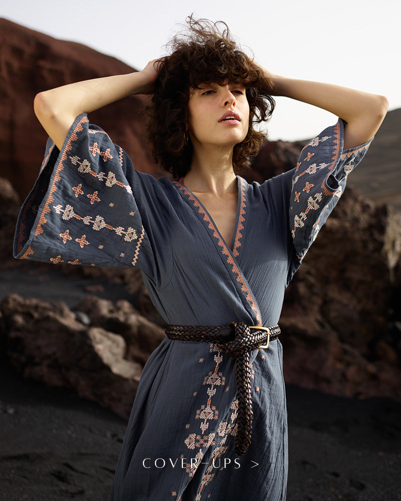 Model wears geometric embroidered kimono in grey, paired with a belt at the waist. Copy on image 'Cover-ups'