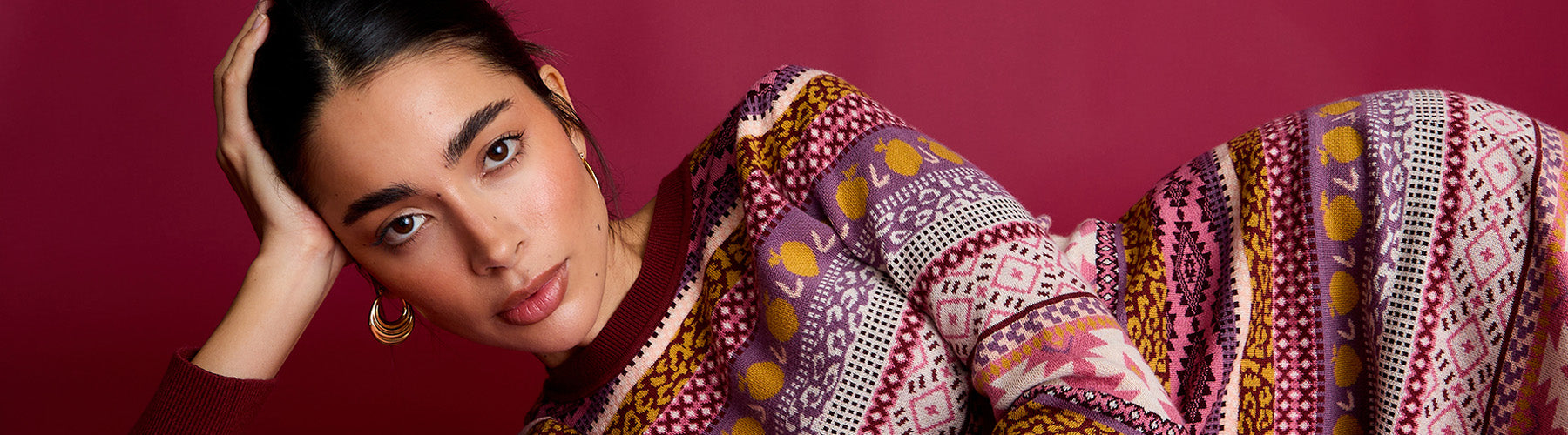 Woman wearing a patterned shawl against a red background
