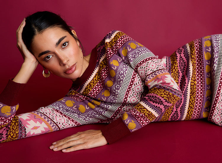 Woman wearing a colorful patterned outfit against a red background