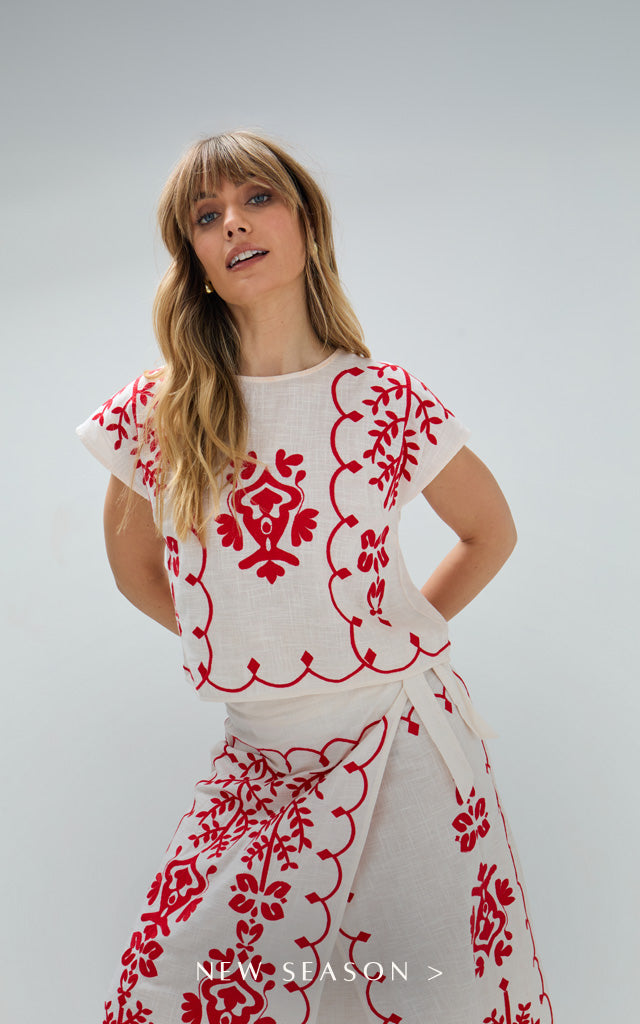 Model styles the Fraya Cross Hatch Embroidered Wrap Midi Skirt In White, with matching Fraya Cross Hatch Embroidered Crop Top In White. Copy on image 'New Season'.