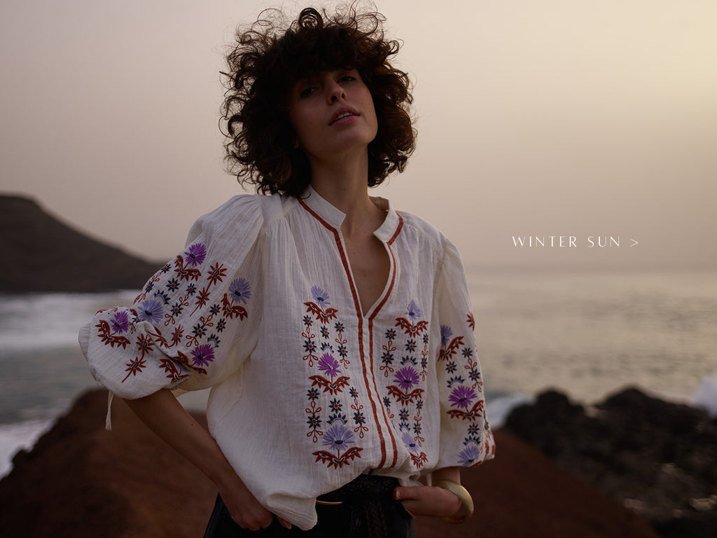 Model wears our Dina V-Neck Embroidered Shirt In Cream. Copy on image 'Winter Sun'