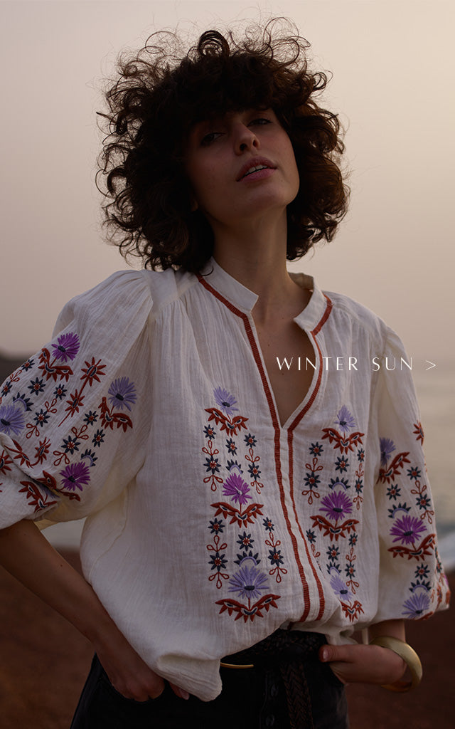 Model wears our Dina V-Neck Embroidered Shirt In Cream. Copy on image 'Winter Sun'