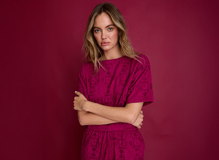 Woman wearing a pink dress against a red background